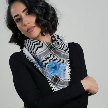 Model wearing SEP mini black and white keffiyeh scarf styled around the neck showcasing the hand-embroidered blue rose motif