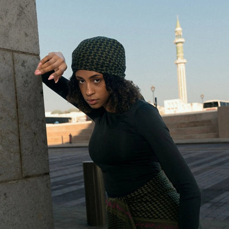 Model wearing SEP khaki green cotton keffiyeh scarf styled as a sleek headwrap bandana outdoors
