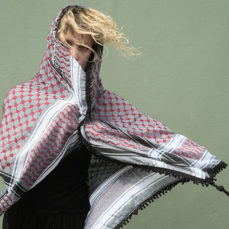 Dynamic portrait of blonde model wearing SEP red and grey keffiyeh scarf styled around her face and shoulders