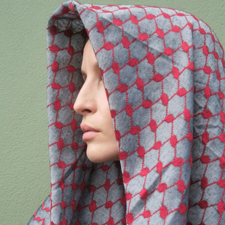 Close-up profile of model wearing SEP red and grey keffiyeh scarf draped over her head like a hood