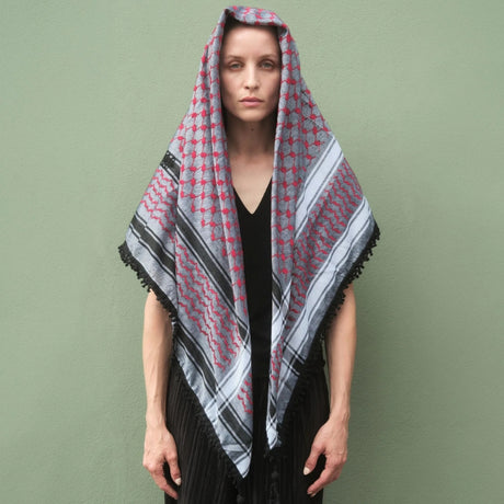 Front view portrait of model wearing SEP red and grey keffiyeh scarf draped over her head and shoulders as a shawl