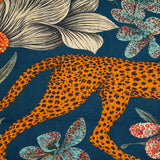 Close-up of the scarf's cheetah motif, showing the spotted coat against green leaves and teal accents