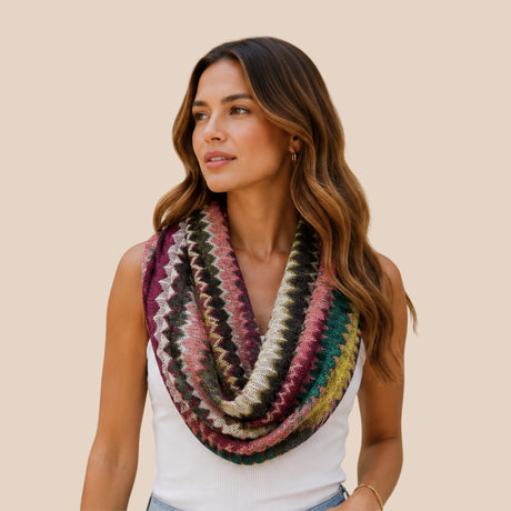 Front view of model wearing You & Eye colorful jewel-tone chevron open-knit snood infinity scarf draped over a white tank top