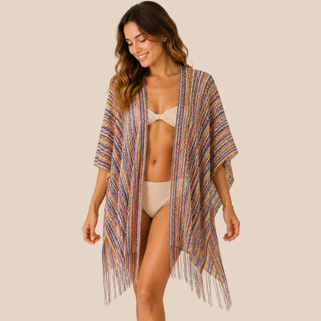 Front view of model wearing You & Eye rainbow fringe crochet short poncho with unstitched sides over a beige two-piece swimsuit
